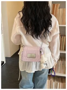 Detail view of the stylish women's shoulder bag with chain strap and cute rabbit pendant.
