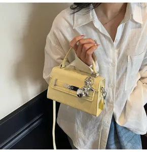 Stylish yellow faux leather crossbody handbag with silver charm for women daily wear details