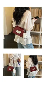 Chic patent leather shoulder bag for women, featuring a metal chain strap and cute plush bunny.
