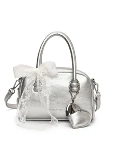 Silver metallic bowling handbag for women with white lace bow and heart charm, stylish purse.