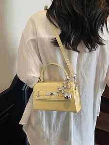 Chic yellow women shoulder crossbody Kelly handbag with cute balloon dog metal charm.