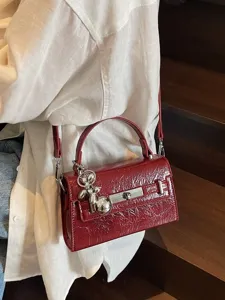 Luxury patent leather handbag for women, chic burgundy shoulder and crossbody Kelly style bag.