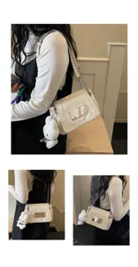 Close-up view of the white patent leather shoulder bag with chain strap and bunny charm.