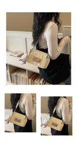 Detail view of a cream patent leather shoulder bag with chain strap and cute plush pendant accessory.