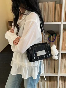 Chic black glossy shoulder bag for women, featuring a metal chain strap and cute bunny charm.