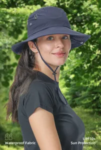 Detail view of the dark blue sun protection bucket hat worn by model outdoors, UV blocking.
