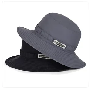 Nahaufnahme von grauen und schwarzen Stoff-Bucket-Hats mit Label und winddichtem Kordelzug.