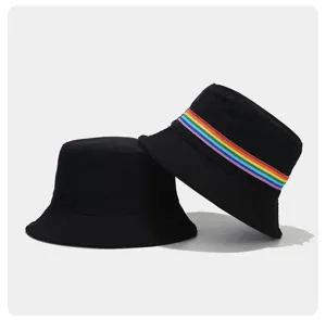 Close-up detail of black bucket hat featuring a colorful rainbow striped ribbon accent.