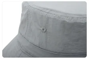 Nahaufnahme Detail eines grauen Fischerhutes mit feinen Nähten und atmungsaktiver Ösenstruktur.