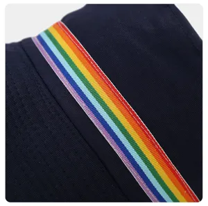Detail view of a navy blue bucket hat featuring a vibrant rainbow striped ribbon band.