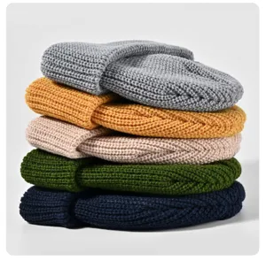 Stapel von bunten Strickmützen, Detailansicht warmer einfarbiger Wollmützen für den Winter.