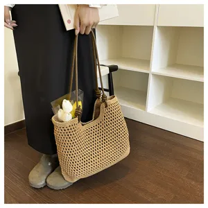 Woven straw tote bag for women, hollow knit shoulder bag with brown handles, casual summer bag.