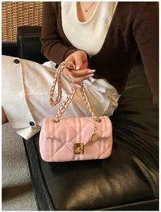 Pink quilted chain shoulder bag, elegant detail view showing metallic lock and strap.