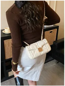 White quilted chain shoulder bag detail shot, showing elegant PU leather and golden hardware.
