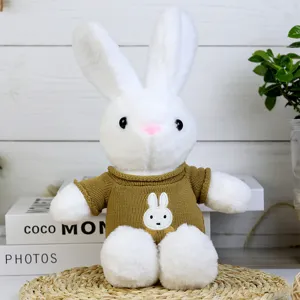 Cute white plush rabbit stuffed toy wearing a cozy brown knitted sweater with cute bunny embroidery.