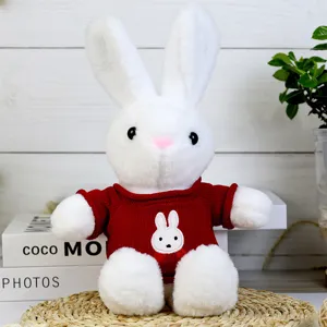 Detailed close-up view of a cute white plush rabbit toy wearing a red knitted sweater.