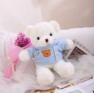 Cute white teddy bear plush toy wearing a soft light blue hoodie with bear patch detail.