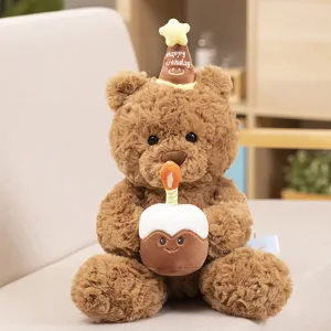Cute brown plush bear holding a birthday cake and wearing a party hat toy detail view.