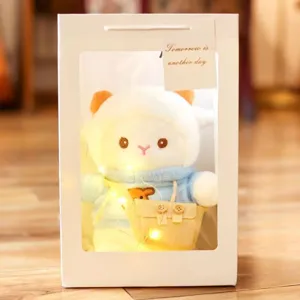 Cute plush sheep doll in white gift box with warm fairy lights and sweet apparel details.