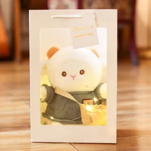 Adorably cute plush sheep doll toy wearing knitted sweater inside clear window gift bag.
