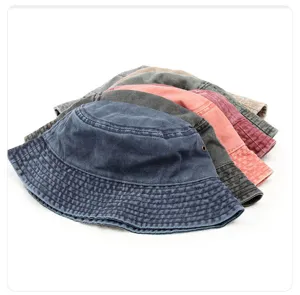 Vue détaillée de chapeaux bob en denim lavé empilés, montrant différentes couleurs et textures.