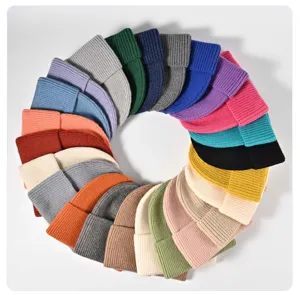 Gros plan détaillé de bonnets en tricot côtelé coloré disposés en cercle pour l'hiver.