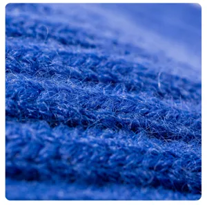 Nahaufnahme der dicken blauen Strick-Wollstoff-Textur, weiches und warmes Wintermützen-Detail.