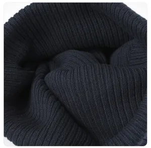Close-up of navy blue knit beanie texture, soft ribbed cotton winter warm hat detail.