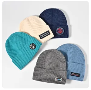 Custom logo embroidered knitted beanie hat, warm autumn winter woolen cap detail view.