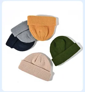 Detailed view of colorful solid knit beanies, thick warm winter fisherman caps for men women.