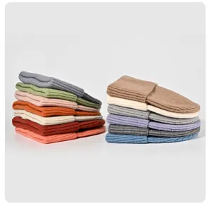 Vue détaillée de bonnets en tricot colorés empilés soigneusement, parfaits pour l'automne et hiver.
