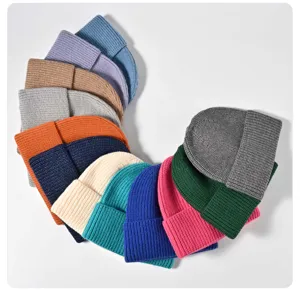 Colorful knit beanies detail shot showing ribbed texture and various fashion colors for winter wear.