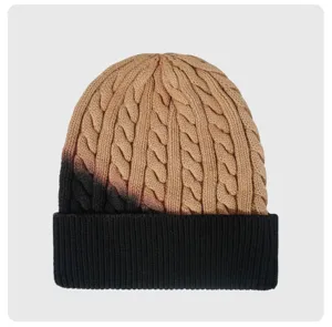 Vista detallada del gorro de punto degradado de invierno con puño acanalado negro clásico.