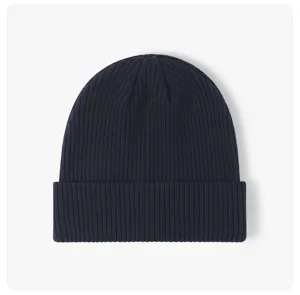 Close-up detail of the dark blue ribbed knit beanie hat texture, warm and cozy winter fabric.