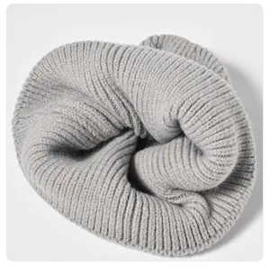 Close-up of a soft grey ribbed knit beanie, detailed winter thermal wool hat texture.