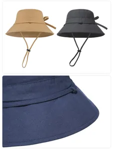 Detailed view of wide brim bucket hat with cute bow decoration and chin strap for sun protection.