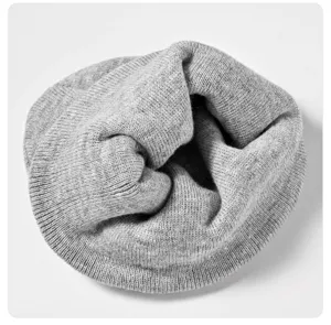 Primer plano detallado del gorro de invierno de punto gris, tejido cálido y grueso