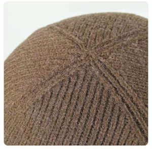 Gros plan détaillé du haut du bonnet d'hiver marron, montrant une texture en tricot côtelé.