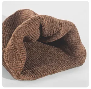 Gros plan détaillé du bonnet d'hiver en tricot marron, texture laine côtelée douce.