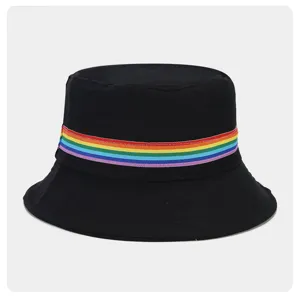 Close-up detail of the black bucket hat featuring a vibrant rainbow stripe ribbon band.