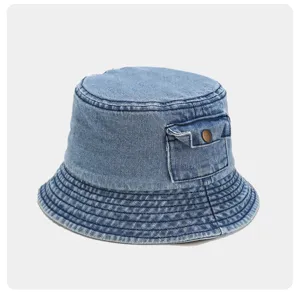 Close-up detail of the washed denim bucket hat featuring a small side pocket and metal snap.
