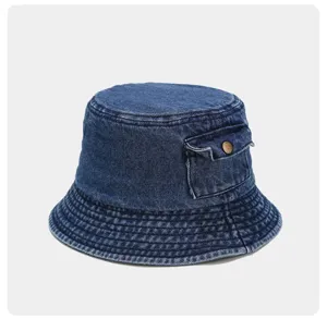 Blue denim bucket hat detail showing side pocket and metal button design, casual summer style.