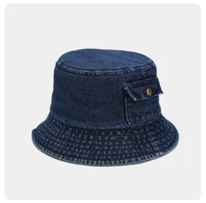 Dark blue denim bucket hat detail showing side pocket and metal button craftsmanship casual.