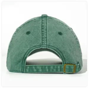 Detailed view of the green washed cotton baseball cap with adjustable metal buckle strap.