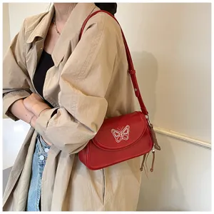 Sac à épaule en cuir rouge avec broderie papillon blanche, design de niche élégant et chic.