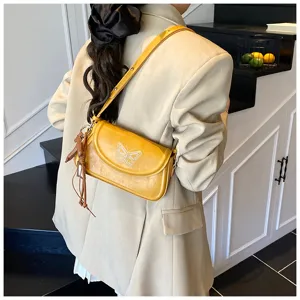 Sac à épaule jaune élégant pour femme avec broderie délicate de papillon et frange.