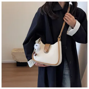 Chic minimalist shoulder bag with contrast trim and cute fluffy charm for daily commuting.