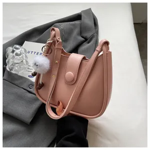 Detailed view of trendy pink women shoulder bag, stylish casual crossbody purse with fluffy charm.