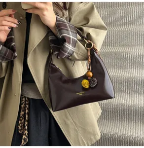 Stylish dark brown patent leather underarm bag for women, trendy hobo shoulder bag with charm.