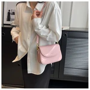 Stylish pink patent leather shoulder bag detail, featuring elegant crossbody and gold hardware.
